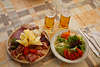106314_Jause aus Wurstsorten Speck mit Kse auf Brett Foto mit Salatteller zum Bier in Glser serviert