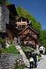 Hallstatt urige Holzhäuser Foto in grüner Berghangkulisse mit Touristen vor Pfad Steintreppe Rundweg zur Soleleitung