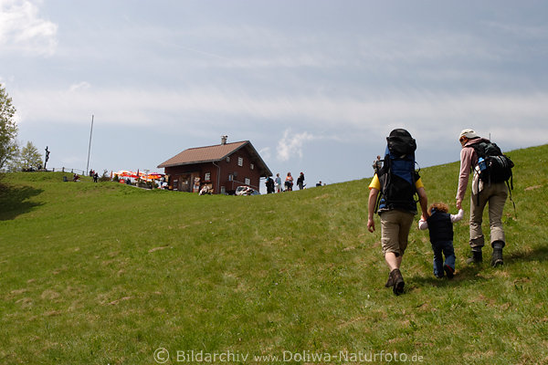 Wanderfamilie mit Kind Rucksack vor Berghtte