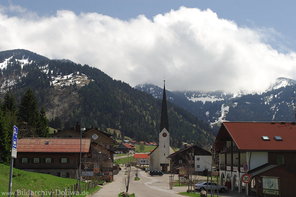 Schlipfhalden Einfahrtstrasse Kirche Wolkenstimmung in Allgu Alpenort