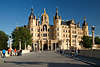 911506_ Schloss Schwerin Fotografie von Inselbrcke in die Frontfassade mit Niklotstatue Bild und Touristen