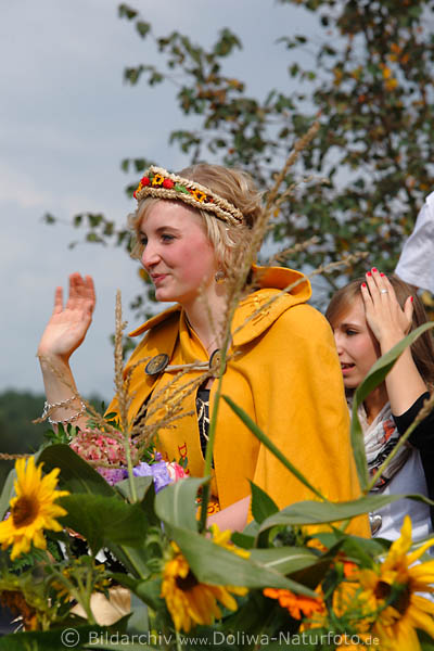 Ernteknigin 2010 in Gelb winkend in Blumen mit Begleitdame