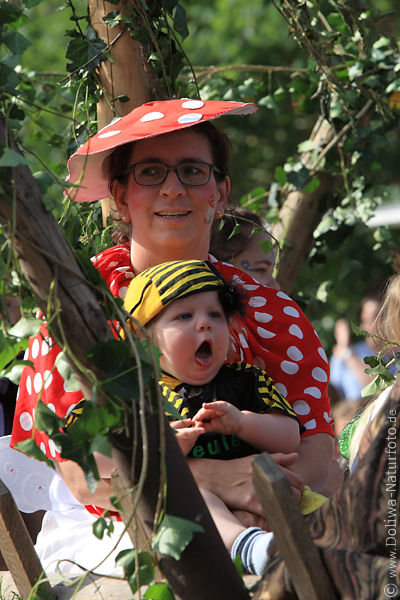 Frau ghnendes Kind Mund offen lustiges Foto mit Mutter roter Hut & Kleid in Blttern