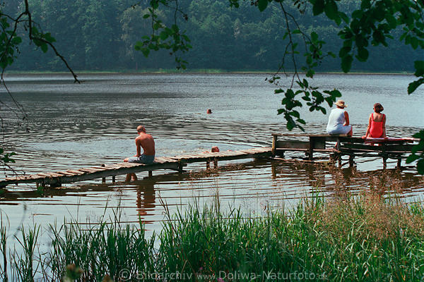Masuren See Badestelle Holzsteg in Wasser Schwimmer sonnende Menschen Schilfufer Naturidylle Urlaubstimmung