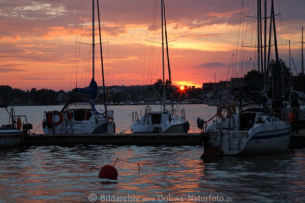 Nikolaiken Rothimmel Sonnenuntergang über Hafen Segler Jachtboote in Wasser Abendstimmung
