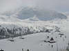 Verschneite Holzhütten im Bergtal Gasienicowa Winter Foto Sennhütten Skiläufer im Schneenebel über Gipfel
