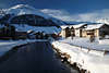 901126_ Celerina Häuser am Fluss Foto unterm Berg in Winter, Oberengadin Alpen romantische Landschaft