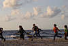 Mädchen mit Jungs am Strand laufen lachend Foto Spass am Meer Wellen Gischt Seeufer