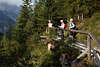 913411_Bergwanderer auf Holzbrcke Fotografie Frauen-Trio auf Naturpfad im Wald am Berghang