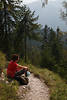 913550_Erholung am Pfad sitzen in Berglandschaft Frau Bild in Natur am Wanderweg im Bergwald