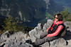 Gipfelsitz Mädchen auf Felsen lächelnde Wanderin in Berghöhe über See-Talpanorama