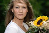 Blondes Mädel hübsche Frau mit Sonnenblumenstrauss in Wind