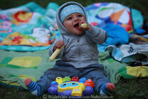Baby Bild Kind Portrt auf bunter Decke sitzen mit Spielzeug frhlich