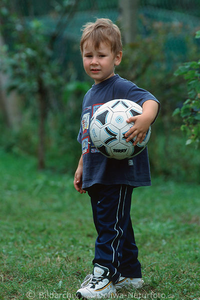 Kind mit Ball unter Arm Foto Junge blond Milchbube kleiner Fussballer Portrt stehend