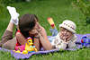57536_ Frau mit Kind Portrait im Freien auf Wiese und Decke liegen, blondes Kindchen in Mtze lachend