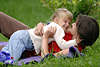 Kind mit Mutter toben auf Wiese frhlich spielen im Grass liegen im Freien