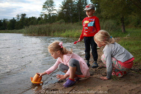 Kinder am Seeufer Wasser Sandspiele