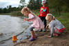 Kinder am Seeufer Wasser spielen Eimer Mädchen mit Junge