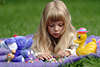 57551_ Blondes Kind, Kindlein alleine auf Decke, Wiese liegen & mit Spielzeug spielen, Kindchen im Freien