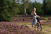 Mädchen mit Fahrrad auf Heide-Wanderweg blühende Naturfoto
