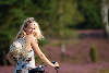 Blondes Mädel mit Fahrrad Sonnenhut in lila blühende Heide Naturbild