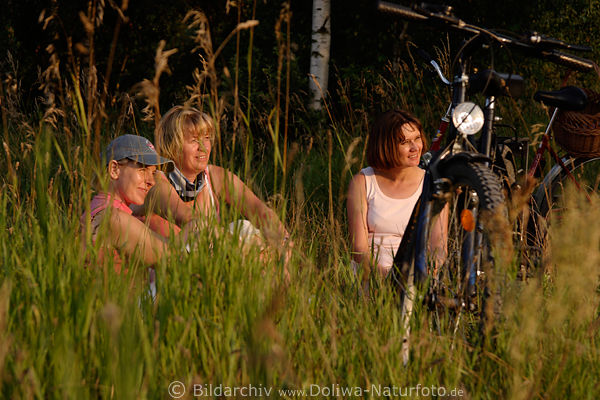 Drei Frauen im Gras bei Romantik Picknick im Abendlicht, Relax in Licht untergehender Sonne