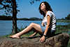 3774_Mädchen sonnen auf Stein sitzend Foto am Seeufer mit Seenlandschaftblick beim Sonnenbad in Freizeit