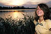 3803_ Lustiges Mädchen, Mädel fröhlich bei Spass am See, lachend vor Schilf beim Sonnenuntergang