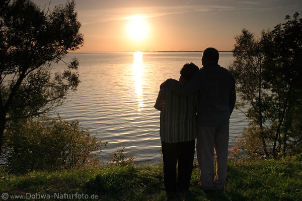 Verliebtes SeniorenPaar umarmt am Seeufer Mann & Frau vor Sonne Romantik am Wasser Abendtreff