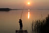 Angler Foto fischen mit Angel werfen vom Steg ins Wasser am Schilf Romantik Abendstille Bild