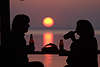 Paar-Silhouetten trinken vor Sonnenkugel über See lila Naturschauspiel
