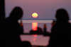 Paar Silhouetten vor Sonnenball Foto über See Romantik Wasserblick untergehende Sonne