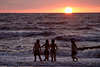 Mädchen baden in Meer Wasser Wellen Foto vor Sonnenkugel am Seehorizont der Ostsee