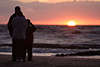 Familien-Trio vor Sonnenuntergang über Seehorizont Romantiktreff
