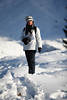 816621_Winterporträt im Schnee Frau in weissen Winterjacke, Weißmütze & Schwarzhose stehend in dicken Schneepracht