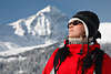 Frau in Rot-Winterjacke vor Schnee-Berg süsse Kopfmütze Sonnenbrille