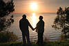 Senioren-Paar Mann Frau am Seeufer vor Sonne Gegenlicht