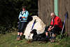 811511_ Wanderer Foto bei Verschnaufspause, Paar mit Hund an Stein & Hüttenwand sitzen in der Sonne