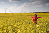 Girl-Freude in Gelbweite Rapsblumenfeld in Frühlingsblüte vor Windräder