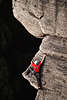 710173_ Kletterer Foto Hände & Füsse breit an Steilwand geklebt Felsvorsprung klettern vor dunklem Abgrund