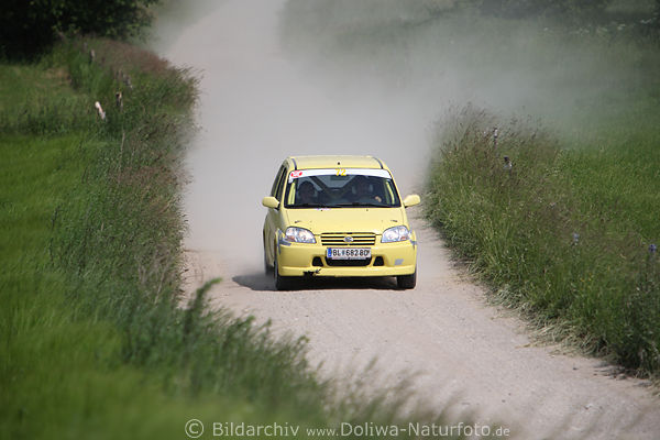 sterreicher Auto-Duo im gelben Kleinwagen auf Schotterpiste in Masuren Rennstrecke Rally Polen