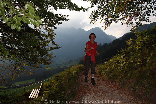 Fitness in Natur Frau laufen auf Pfad mit Bergblick Photo zwischen Blttern an Bank mit Aussicht