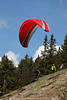 1201018_ Flugstartfoto Paragleiter Lauf Startbild am Berghang vor Fliegerkollegen unter rot Gleitschirm
