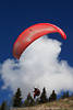 1201068_ Paragleiter Pilot am Berghang unter Rotschirm Startflugfoto vor Wolke am Blauhimmel