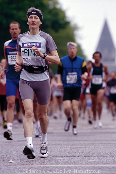 Marathon Frau Luferin vor Mnner auf Laufstrecke