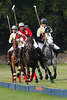 809896_ Lustiges Polofoto: Polotruppe mit Polosticks in Hand zu Pferd entlang der Bande in Galopp