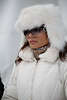 902712_ St. Moritz Snow-Polo Charme & Beauty, dunkelhaarige hübsche Frau in Weißer Wintermütze & Winterjacke