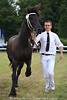 1407657_Schwarzer Pferd mit Betreuer in Weiss Mann lcheln Laufportrt Foto von Friesenschau