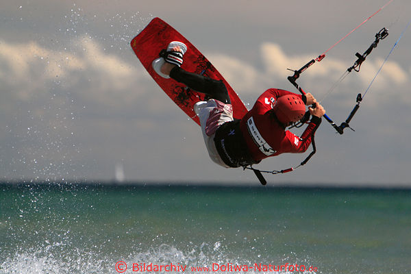 Kitesurfer Salto Aktionbild spektakulrer Sprung vom Wasser in Luft schweben an Segelleine