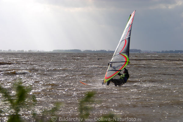 Windsurfer dicht ber Wasser am Rigg Segel hngen in Windsurfing Sportfoto